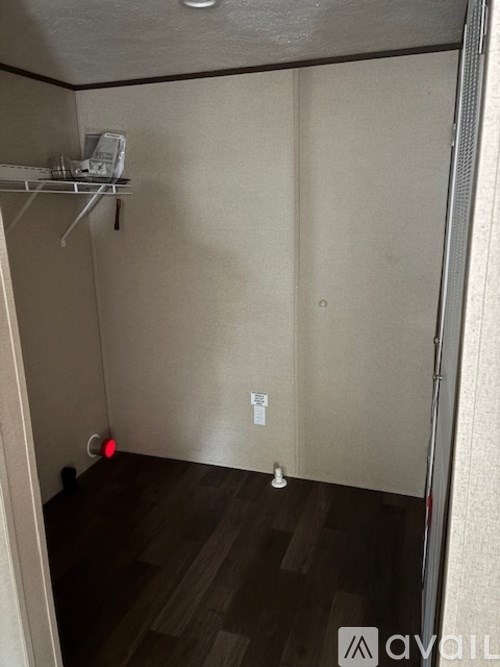 A small, empty room with a red light on the floor.