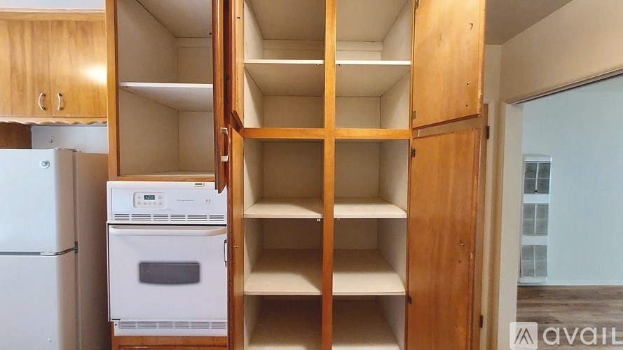 A kitchen with wooden cabinets and a white refrigerator.