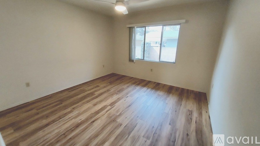 A room with wooden flooring and a window.