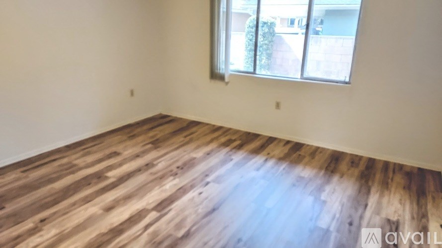 A room with wooden flooring and a window.