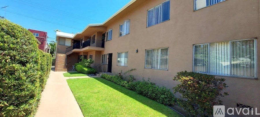 A beige apartment building with a green lawn in front.