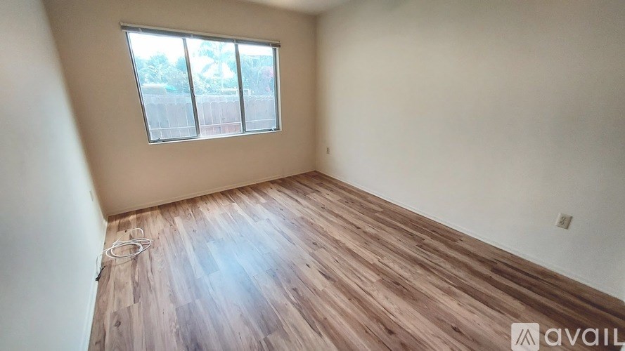 A room with wooden flooring and a window.