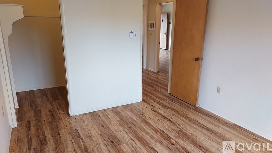 A room with wooden flooring and a white door.