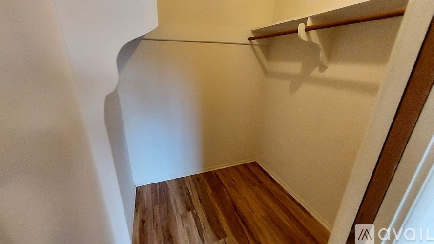 A white wall with a wooden shelf and a white door.
