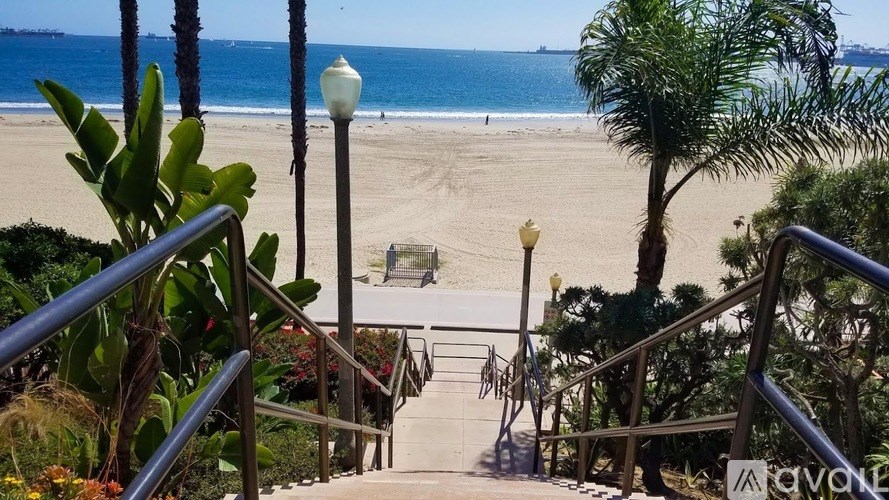 A beach scene with a staircase leading down to the sand.