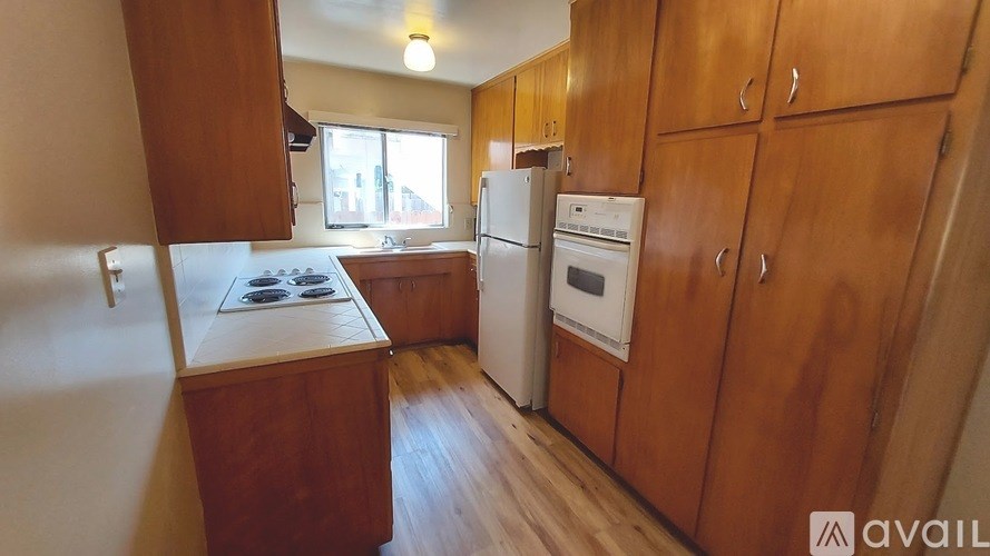 A kitchen with wooden cabinets and appliances.