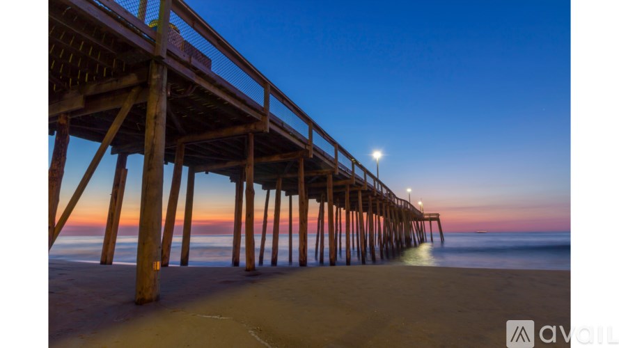 A pier extends into the water under a twilight sky.