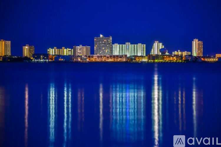 A city skyline is reflected in the water at night.