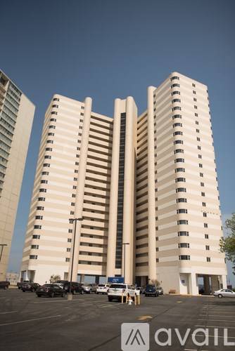 A tall building with a parking lot in front of it.