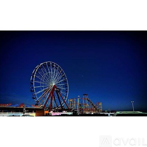 A large Ferris wheel is lit up at night.