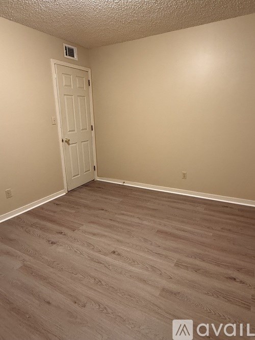 A room with a door and wooden flooring.