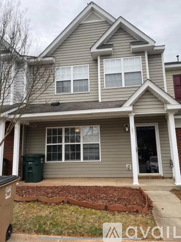 A house with a grey siding and a brown roof.