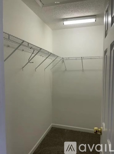 A small, empty room with a carpeted floor and a door on the right.