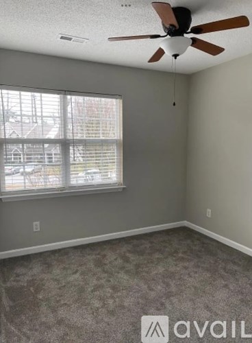 A room with a ceiling fan and a window.