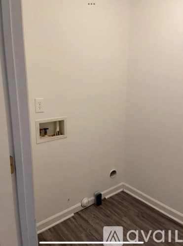 A room with a white wall and a small window.