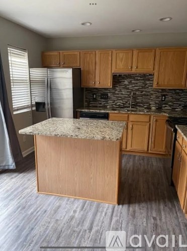 A kitchen with wooden cabinets and a granite countertop.