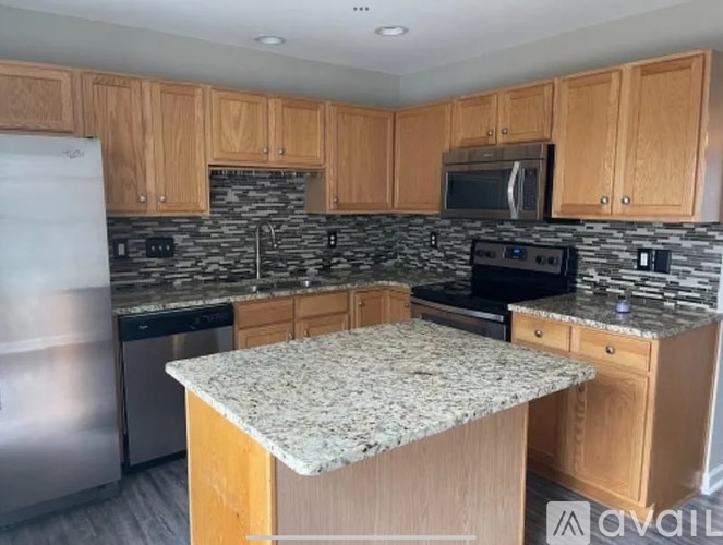 A kitchen with wooden cabinets and granite countertops.