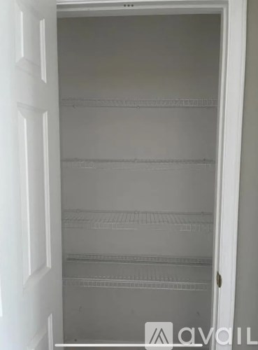 Empty white refrigerator with a door open.