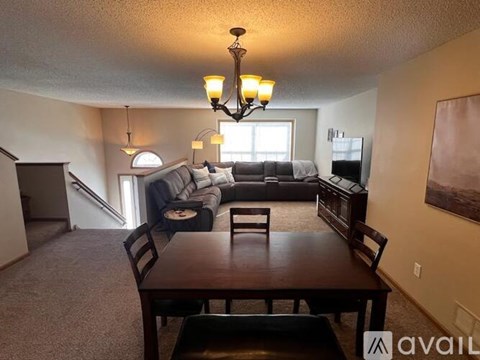 A living room with a couch, chairs, and a dining table.