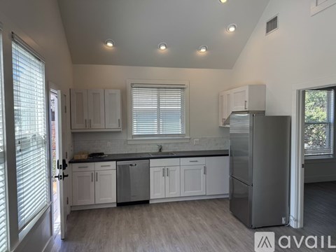 A kitchen with white cabinets and a refrigerator.