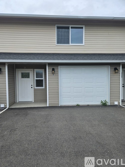 A house with a grey garage door and a white door.