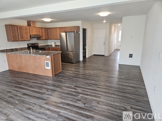 A kitchen with wooden cabinets and a refrigerator.