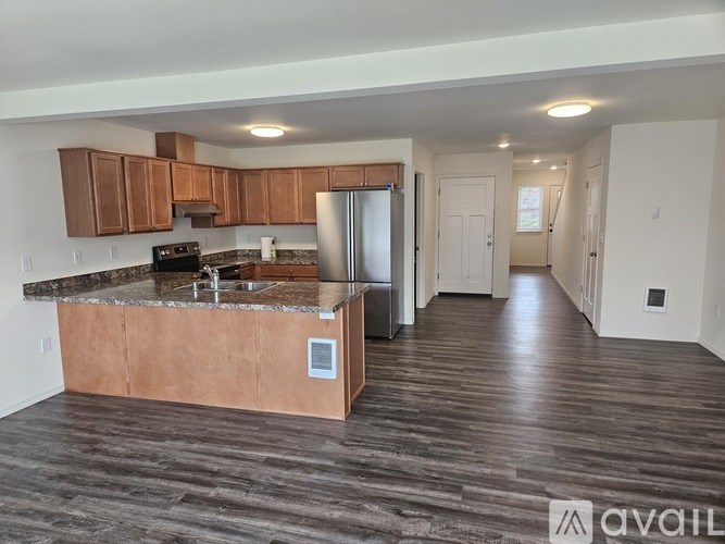 A kitchen with wooden cabinets and a granite countertop.