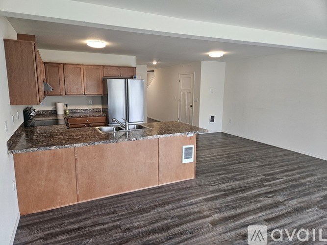 A kitchen with brown cabinets and a stainless steel refrigerator.