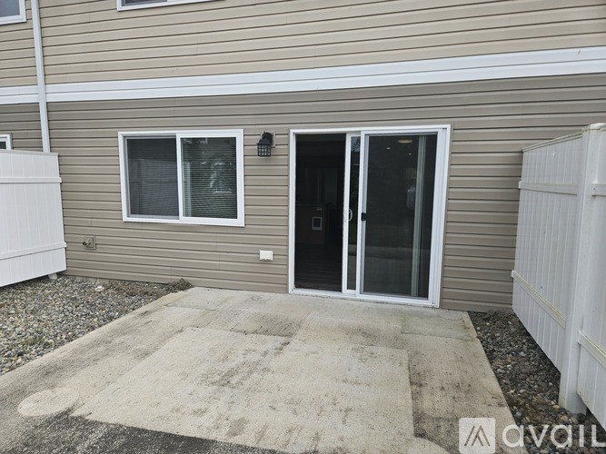 A house with a brown siding and a white fence.