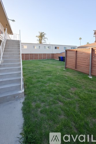 A backyard with a wooden fence and a staircase leading to a house.