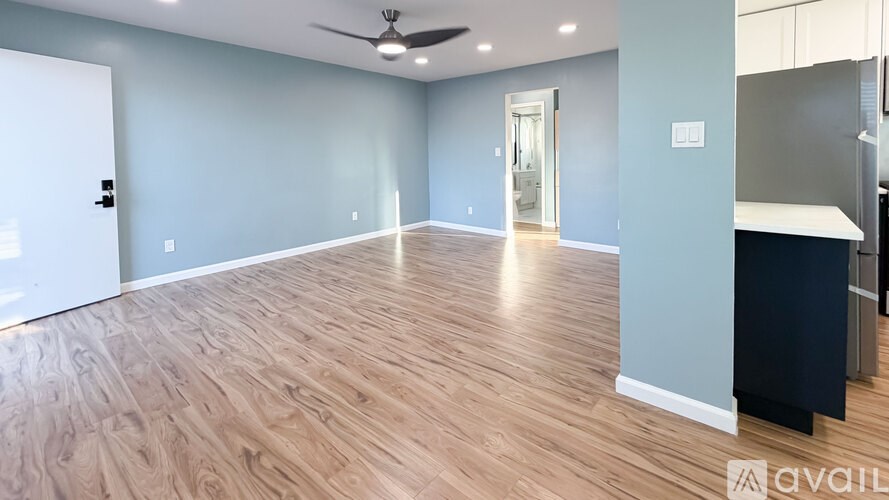 A room with wooden flooring and a ceiling fan.