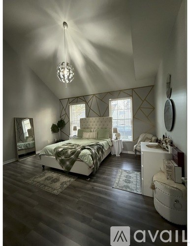 A bedroom with a large bed and a chandelier.