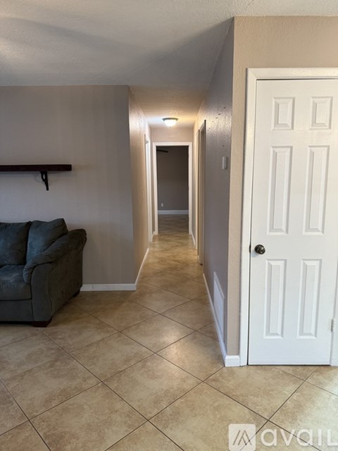 A living room with a grey couch and a white door.