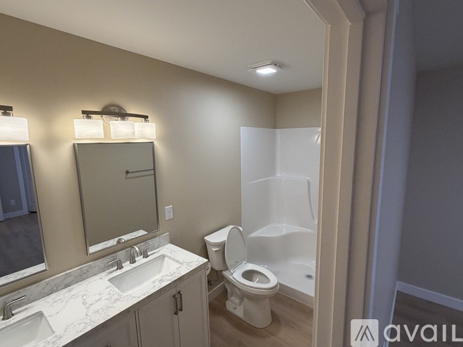 A bathroom with a toilet, sink, and mirror.