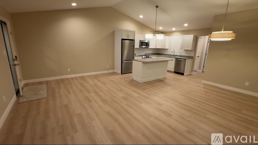 A kitchen with wooden floors and white cabinets is available.