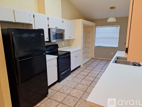 A kitchen with black appliances and white cabinets.