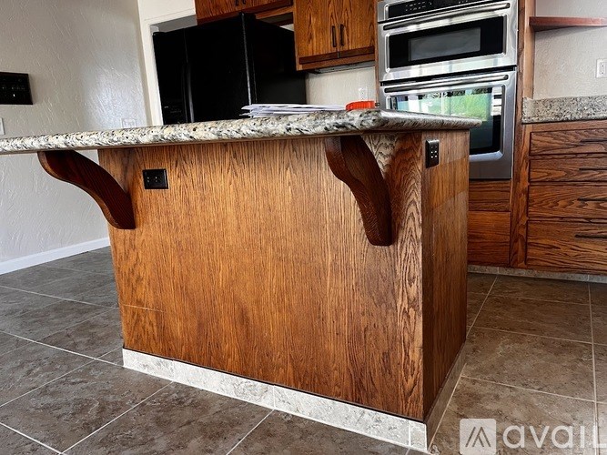 A kitchen island with a wooden top and a countertop with a cutting board on it.