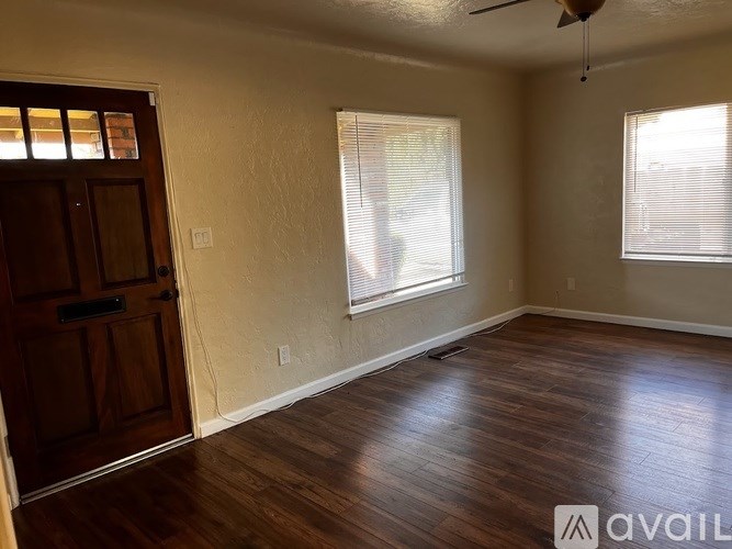 A room with wooden floors and a ceiling fan.