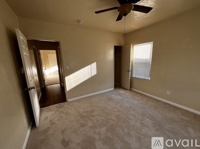 A room with a ceiling fan and carpeted floor.