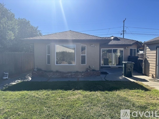 A house with a grey roof and a white fence.