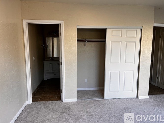 A room with a white door and a white closet with a coat hanger.