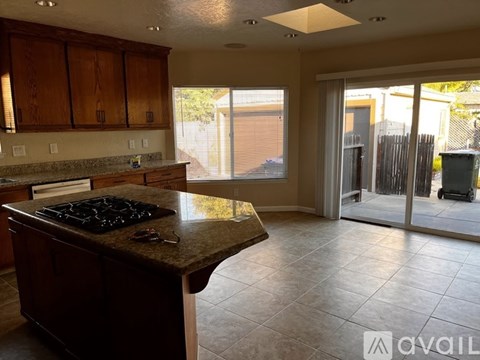 A kitchen with a granite countertop and a stove top oven.