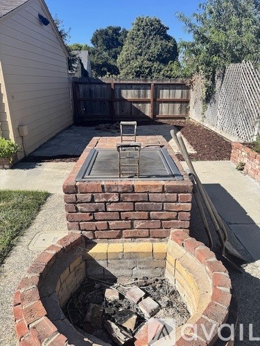 A brick fireplace with a fire burning inside.