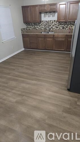 A kitchen with wooden cabinets and a stone backsplash.