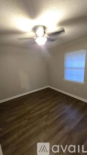 A room with a ceiling fan and a window.