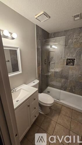 A bathroom with a toilet, sink, and shower.