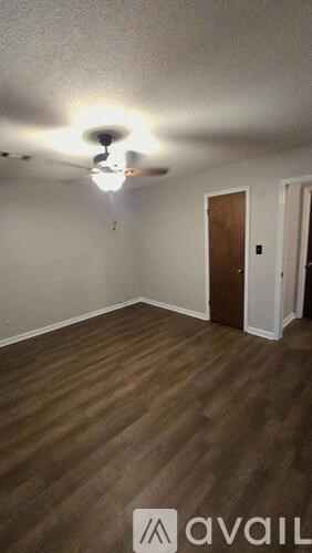 A room with a ceiling fan and wooden flooring.