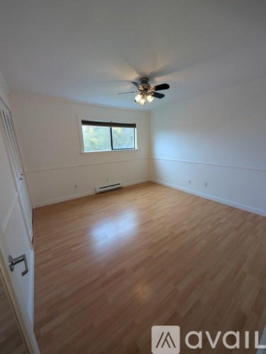 A room with wooden flooring and a ceiling fan.