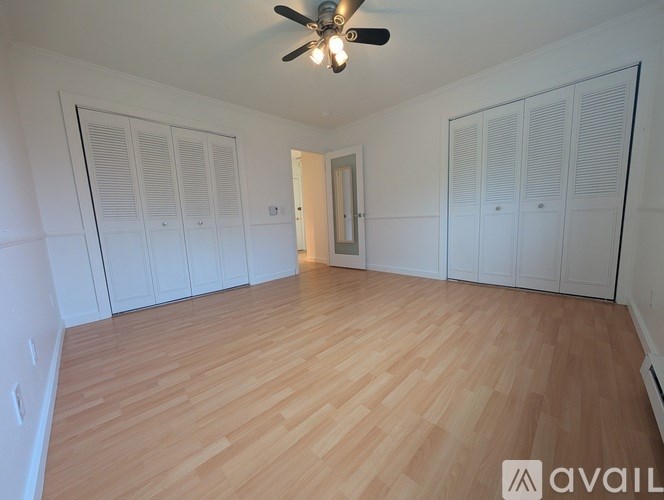 A room with wooden flooring and a ceiling fan.