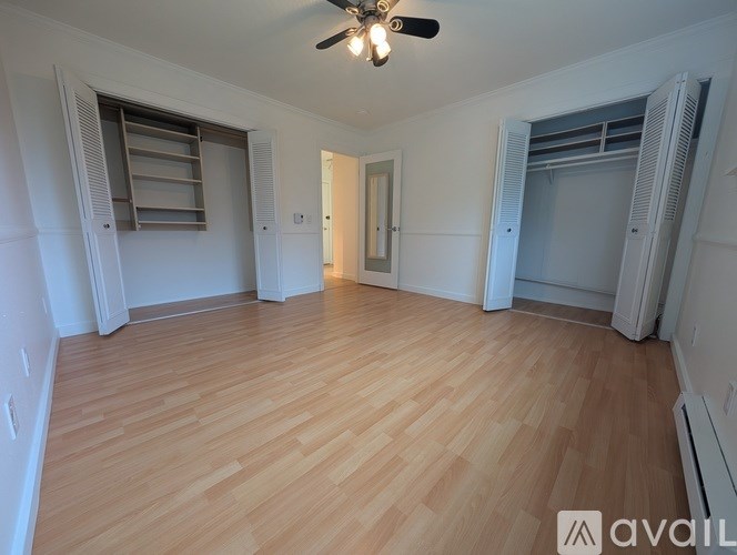 A room with wooden flooring and a ceiling fan.